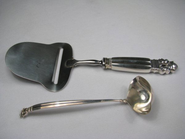 GEORG JENSEN STERLING SILVER CHEESE SLICER & LADLE: Georg Jensen sterling silver cheese sliver and small ladle. Each piece is stamped on the handles Denmark, Sterling, Georg Jensen. Cheese slicer has a hollow sterling silver handle and a stainless stee