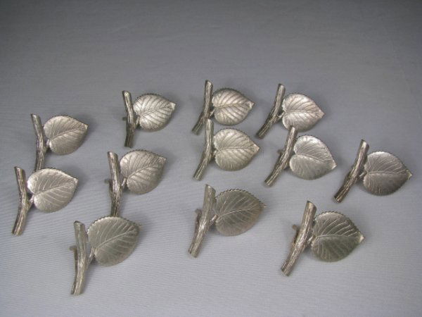 TIFFANY & CO STERLING SILVER PLACE CARD HOLDERS: Twelve Tiffany & Co sterling silver leaf shape place card holders. Stamped on the back of each leaf reads Tiffany & Co., Makers, Sterling. Each card holder measures 1" tall by 2" wide by 3/4" deep. We