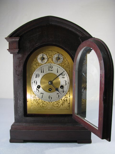 VINTAGE GERMAN ETCHED FACE MANTLE CLOCK K C CO: German walnut finish bracket style clock. Dial is etched metal. Time and strike. Working mechanism. Case has alligatoring to finish. Measures 17" tall x 12" wide x 8" deep. Weighs 14 lbs. 2 oz.