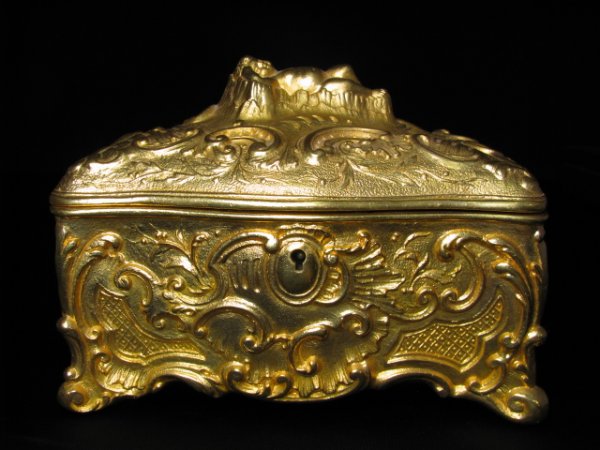 GILT PAINTED ANTIQUE SATIN LINE JEWEL CASKET: Antique jewel casket with pink silk pillow lining. White metal with later gold paint. Measures 7" x 5" x 5 1/2" tall.