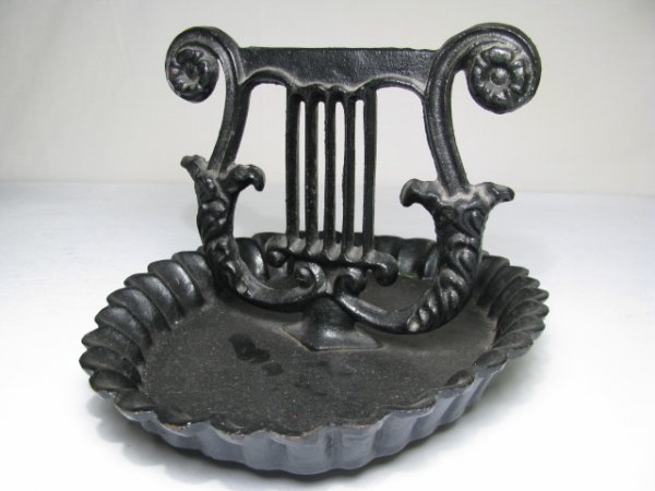 ANTIQUE CAST IRON MUSIC LYRE BOOT SCRAPE: Antique cast iron boot scraper is in the shape of a music lyre. Bottom shows a raised anchor with a V & M on either side and is numbered 11-1. Measures 8" tall by 11" long. Good condition, see images.