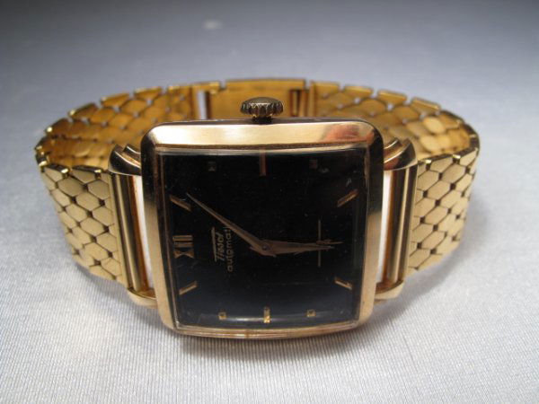 TISSOT 18KT GOLD WRISTWATCH CIRCA 1950'S: Men's 18kt gold wrist watch, the large square black enamel dial signed Tissot with gold dot and bar numerals, gold hands, beveled glass bezel and solid 18 kt gold flexible bracelet. Stamped 18k with h