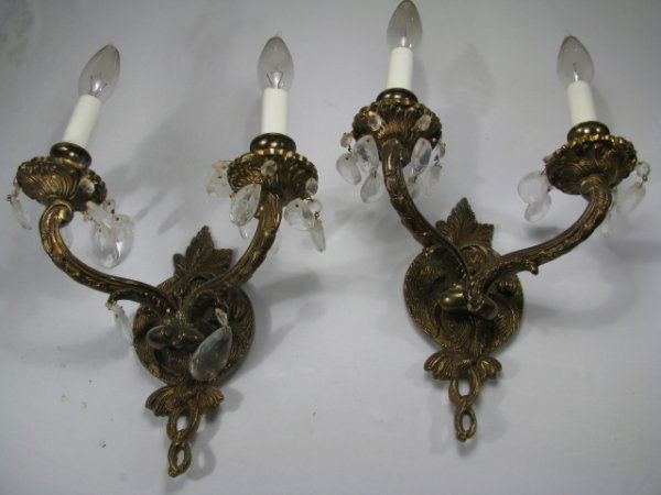 PAIR BRASS TWO ARM WALL SCONES w CRYSTALS: Pair electrical brass two arm wall sconces with crystals. No maker marks. Measures 9" tall by 9 1/2" wide by 6 1/2" deep. Sconces are missing some crystals. Approx. weight 6 lbs. As with all electrica