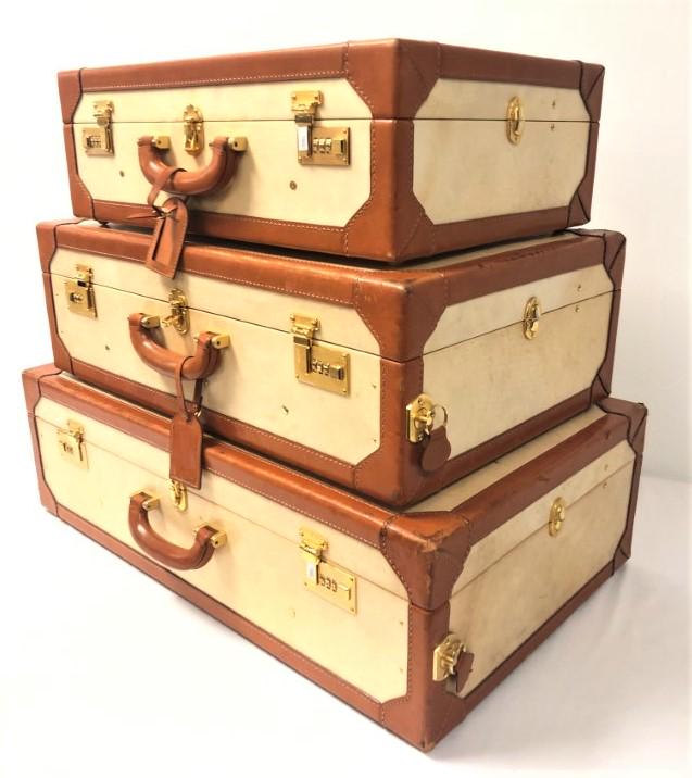 SET OF THREE GIORGIO'S OF PALM BEACH SUITCASES: Set of three vintage suitcases by Giorgio's of Palm Beach. Leather lined, with brass hardware. Larger two suitcases have wheels and pull-out handles. The largest measures 19" x 30.5" x 9" wide. Medium