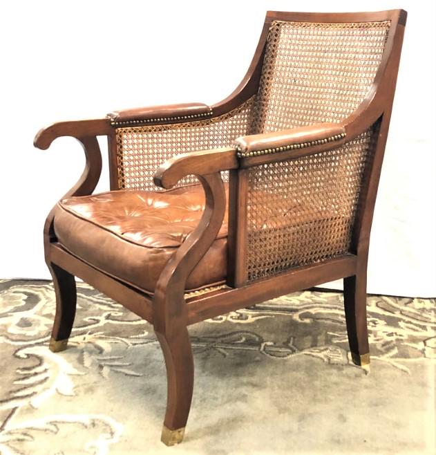 VINTAGE CANED WOOD ARMCHAIR: Vintage carved wood armchair with a woven cane seat, back, and sides. Measures 35.5" tall x 24.5" wide and 30" deep. Leather seat cushion. Condition: small chip to edge of right arm, no damages to can