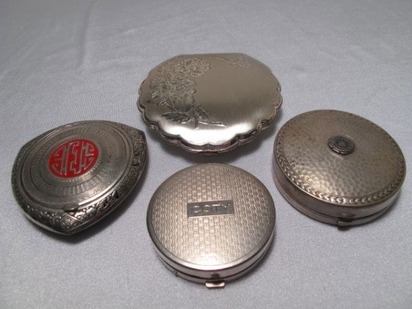 FOUR ASSORTED SILVER TONED COMPACTS: First is a small round Cory compact with basket weave engraving on the lid, base, and interior. Interior and exterior are in good condition. Measures 1 3/4" by 1 3/4". Second is an Ohio State Universi