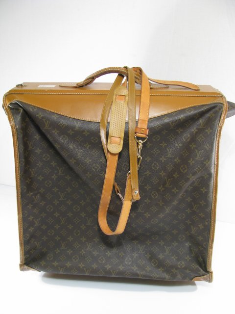 VINTAGE LOUIS VUITTON LUGGAGE FOLDING GARMENT BAG: 1960's -1970's Louis Vuitton luggage folding garment bag with zipper openings and old lower compartment. Sold with four Louis Vuitton luggage hangers and two leather straps. When bag is open and layin