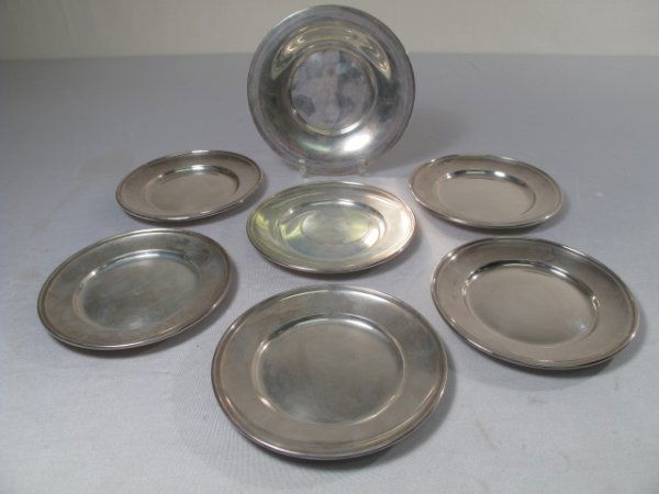 STERLING SILVER GORHAM COASTER AND 6 BREAD PLATES: Gorham mark on back of wine coaster at 7" wide and the other 6 bread plates measure 6 1/2" wide. Surface scratches. Troy weight: 20 oz. Shipping weight: 1 lb 3 oz. (UPDATED 06/20/09 to correct troy we