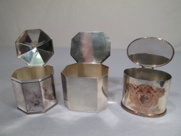 THREE SILVER PLATED TEA CADDY BOXES: Three silver plated tea caddies. Largest is the octangular which measures 3 1/2" x 3 1/2". Smallest is the English oval silver on copper caddy with engraved floral design and center shield which measu