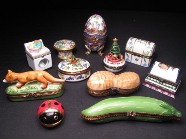 ELEVEN LIMOGES & STYLE NOVELTY PILL BOXES C20th: Eleven Limoges and Limoges style novelty pill boxes in various forms including a fox, a ladybug, and a peanut. Six are signed Limoges, and most are hand-painted. Longest dimension is 4 1/2". Egg pill 