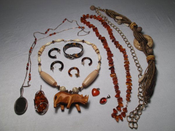 GROUP COSTUME JEWELRY AMBER SHELL WOOD STONE ETC: Group lot of assorted costume jewelry to include large and small amber pendants, amber and silver tone fob with mirror, amber necklace, plastic tortoise shell style bangle bracelet and matching earrin