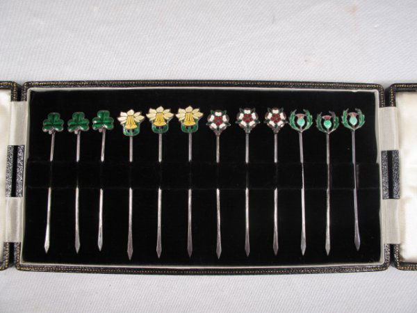 STERLING SILVER ENAMELED COCKTAIL PICKS LEATHER BO: Leather lined case with 12 sterling silver with enameled heads cocktail picks. Each pick measures 3" long. Box is 8 1/2" long x 4" wide x 1" deep. Total weight is 7 oz.