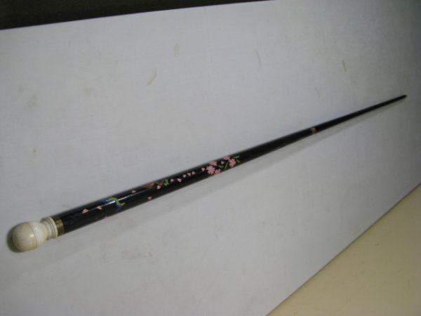 TALL CARVED PAINTED POOL CUE w/ CARVED IVORY: Tall black lacquered carved and painted wood cue with peacock and flowers design. Ivory knob at the top. A brass band is at the top underneath the ivory ball and in the middle. Measures 4' 9" tall. Sh