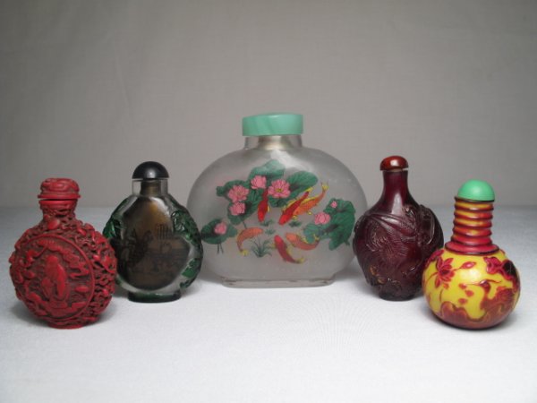 FIVE ASIAN SNUFF BOTTLES PEKING GLASS CINNABAR: Five Asian snuff bottles, late 20th Century. Includes a cameo yellow Peking glass bottle, a cinnabar type bottle, an amber type bottle and two glass bottles with painted interiors. Largest bottle is 3