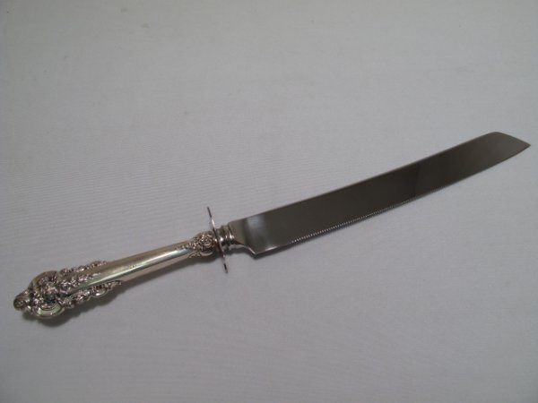 WALLACE GRAND BAROQUE STERLING SILVER CAKE KNIFE: Wallace Grand Baroque pattern silversmith sterling silver hollow handle cake knife with original box. Sterling is stamped on the handle. Knife measures 12 3/4" long by 1 1/4" wide. Condition is good,