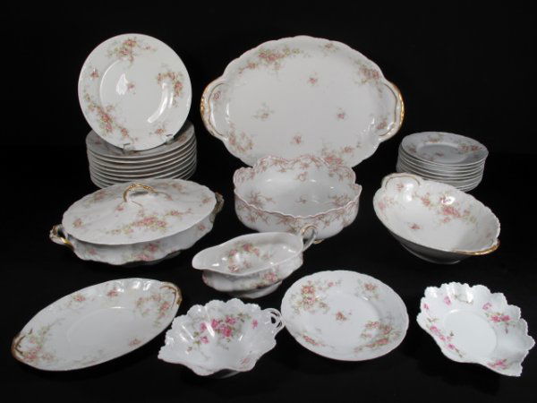 LIMOGES PORCELAIN FLORAL DISHES ASSORTED 29 PCS: Group assorted Limoges dishes with rose and gilt accents. Plates, bowls, nappy platters, covered casseroles, etc. Largest measures 16 1/4" long x 11 1/2" wide and smallest pieces are plates at 6 1/2"
