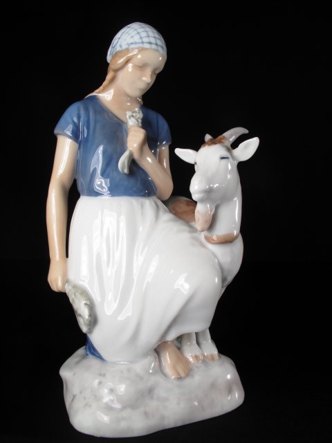 BING & GRONDAHL FIGURINE GIRL AND GOAT SIGNED: Bing and Grondahl hand painted porcelain figurine of a girl feeding a goat. Mold # 2180. Signed on the base by Axel Locher. Height: 7 3/4". Width: 5". Weight: 1.0 lbs. Condition: good.