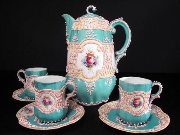 ANTIQUE MORIAGE DEMITASSE COFFEE POT w 3 CUPS/SAUC: Antique robin's egg blue moriage coffee pot and three demitasse coffee cups and saucers. Hand painted floral medallions. Raised slip decoration. Height of coffee pot: 9". Width of pot to back of handl