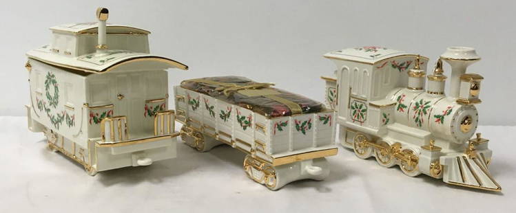 LENOX HOLIDAY JUNCTION THREE PIECE PORCELAIN TRAIN: Lenox"Holiday Junction" three piece porcelain train. Engine measures 6.75" tall x 12" long and 4.35" wide, wagon measures 13" long, and caboose 12.5" long. Each piece marked by maker. Condition: