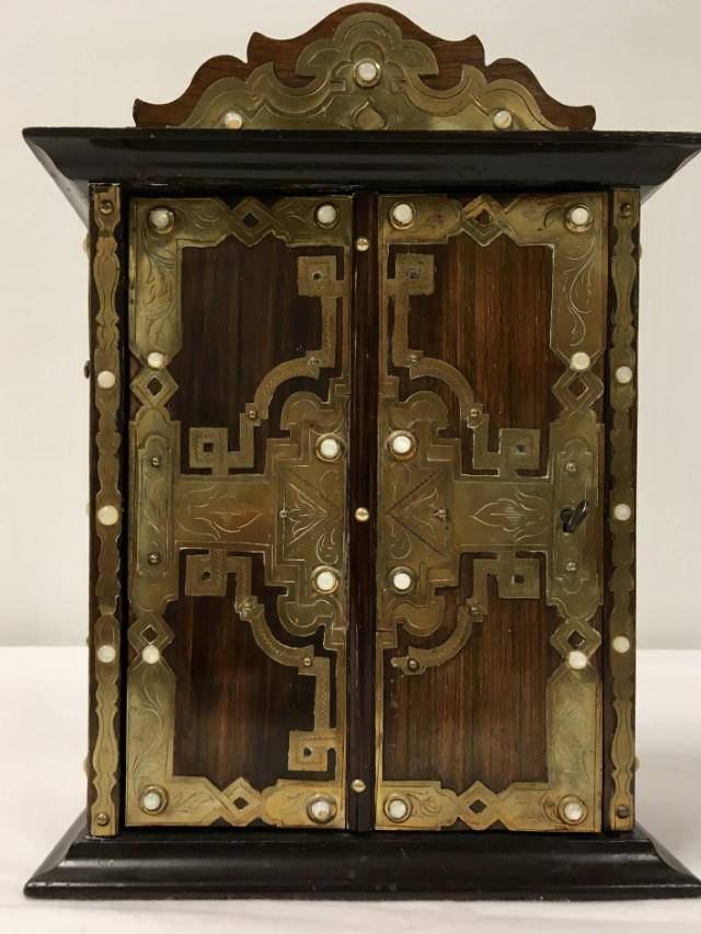 INDO-ASIAN WOOD & BRASS MINIATURE LIQUOR CABINET: Indo-Asian wood and brass mounted miniature liquor cabinet measuring 10.75" tall x 8.25" wide x 4.5" deep. Hidden door design. Condition: good, minor signs of normal age and use, see images. Weight: 2