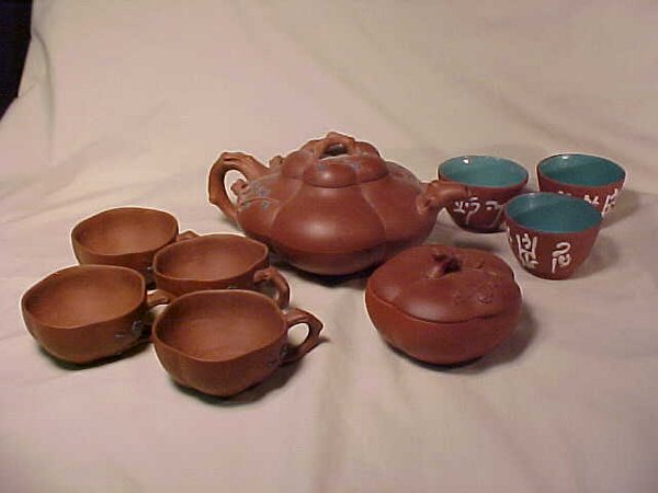 BROWN POTTERY TEAPOT CUPS CREAMER SUGAR T: BROWN POTTERY TEAPOT CUPS CREAMER SUGAR Teapot 8 1/2" wide x 4 1/2" high, sugar 3 3/4" wide x 2 3/4" high, cups with handles 2 7/8" wide x 2" high. Numerous cracks on teapot, handle to one sugar dish