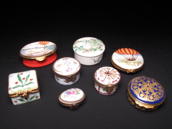 EIGHT PORCELAIN PILL BOXES LIMOGES HAND PAINTED: Eight porcelain pill boxes including six Limoges, France boxes, most of which are hand painted. Largest is 1 7/8" in diameter and 1" high. Smallest is egg shaped and is 1 1/8" long. Various shapes and