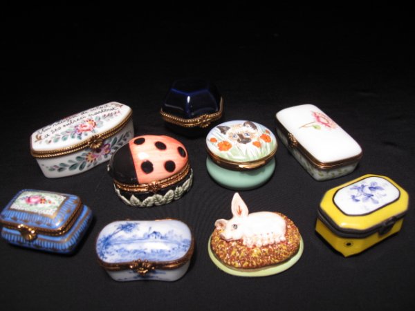 NINE COLLECTIBLE PILL BOXES LIMOGES HAND PAINTED: Eight late 20th Century pill boxes and one paperweight. Lot includes six porcelain Limoges pill boxes. Largest box measures 2 7/8" by 1 1/2" wide. Smallest is 1 3/4" long by 1" tall. Total weight 0.9 