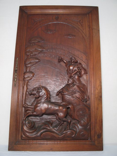 ANTIQUE SIGNED WOOD PANEL CARVING OF A CHARIOT: Antique signed wood carving of a chariot, classical figures, and horses in an amphitheater. Circa 1900. Signed by the artist, M. Bianchi, l.r. Relief panel is a carved door from a piece of furniture. 