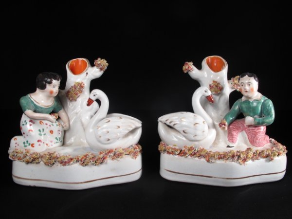 TWO ANTIQUE STAFFORDSHIRE SPILL VASES BOY & GIRL: Two antique Victorian English Staffordshire spill vases, circa 1850. A boy and a girl feeding swans. Height of each: approximately 5". Width of bases: approximately 5 1/2". Total weight: 2.4 lbs. Deal