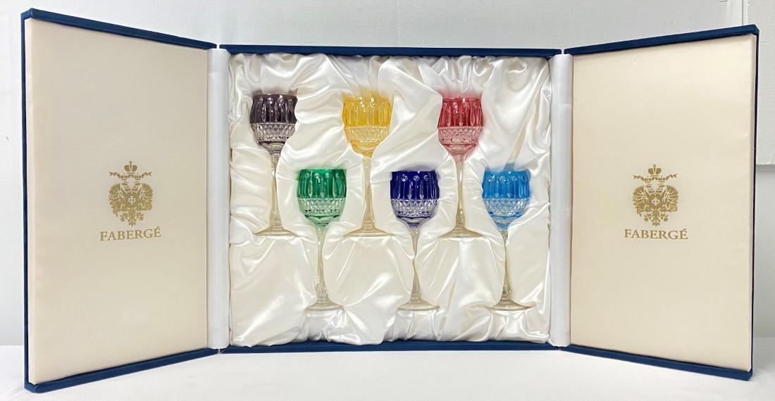 SIX FABERGE "XENIA" COLORED CRYSTAL WINE HOCKS: Lot of six Faberge "Xenia" crystal cut to clear wine hocks / stems. All held in original blue velvet lined presentation box with certificate of authenticity. Each stem measures 8.25" tall and is signe