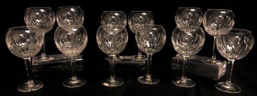 TWELVE WATERFORD MILLENIUM LOVE BALLOON WINE STEMS: Lot of 12 Waterford Millenium Love pattern crystal balloon wine glasses, each 7.75" tall. Each one marked on base. Condition: flake to rim of one wine glass, see images. Weight: approx. 10 lbs.