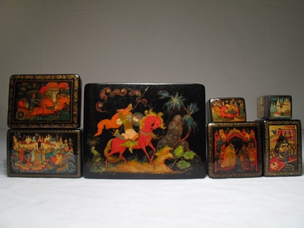 SEVEN RUSSIAN BLACK PAINTED LACQUER BOXES: Seven Russian and Soviet era black painted lacquer boxes. Second half of the 20th Century. Some signed. Allegorical and landscape scenes. Largest measures 5 1/8" x 4" by 1 3/4" tall. Smallest measures