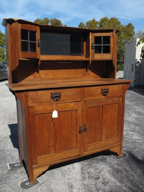 AMERICAN ARTS & CRAFTS OAK BUFFET LEADED PANES: American two piece oak Arts & Crafts two piece buffet with leaded pane display windows. Iron pulls. Height: 62". Width: 54". Depth: 19 1/4". Weight: over 100 lbs. Condition: appears to have been refin