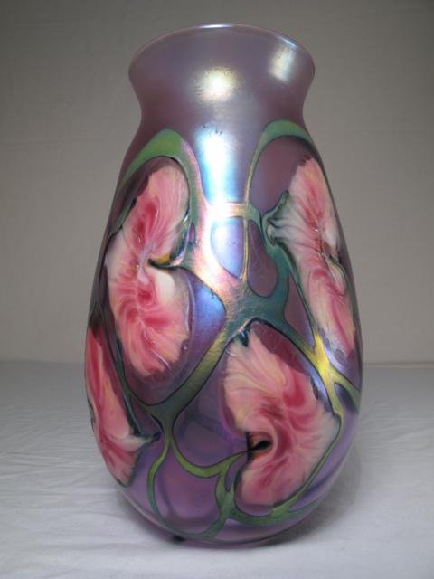 CONTEMPORARY STUDIO IRIDESCENT GLASS VASE SIGNED: Contemporary studio art glass vase illegibly signed by the artist and dated 1990. Handsomely decorated with stylized pink flowers with blue aurene tendrils. Height: 9 1/2". Width at widest point: 5 1/
