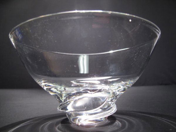 STEUBEN CLEAR GLASS FLARED CENTER BOWL: Steuben clear glass flared center bowl, late 20th Century. Etched signature on underside of base. Height: 4". Diameter at mouth: 7". Weight: 1.6 lbs. Condition: good.