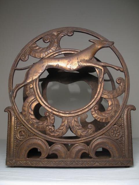 ART DECO CIRCULAR FORM MAGAZINE RACK GREYHOUNDS: Art Deco iron circular form magazine rack decorated with greyhounds. Circa 1920. Height: 13 1/2". Width: 12 1/4". Weight: 11.6. Condition: overall wear to the original patina.