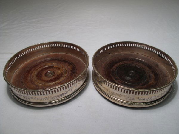 PAIR ANTIQUE ENGLISH SILVER WINE COASTERS: Pair of antique English silver wine coasters, floral design and reticulated border, wooden bases. Measure 4 3/4" x 1 1/4". Weight: .6 lb. Condition: good