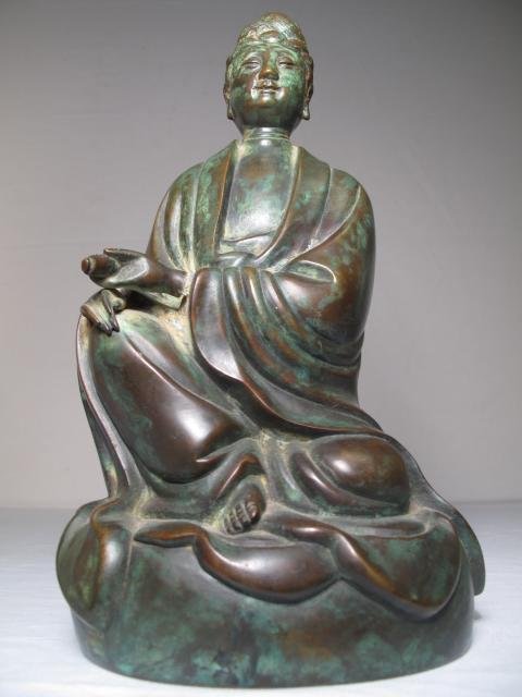 SOUTHEAST ASIAN BRONZE FIGURE MAN HOLDING SCROLL: Southeast Asian bronze figure of a man holding a scroll. 20th Century. Height: 10 1/2". Width: 6" at the widest point. Weight: 6.6 lbs. Condition: good with applied verdigris patina.