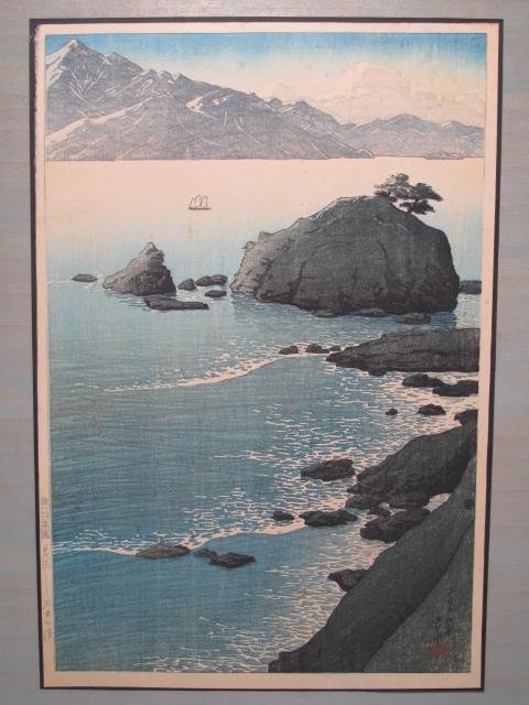 KAWASE HASUI WOODBLOCK: KUDE BEACH WAKASA: Circa 1920's Japanese woodblock print by Kawase Hasui, (1883-1957) titled "Kude Beach, Wakasa." Published by Wantanabe Shozaburo. Notations, left margin and signed lower right. Print measures 10" x 15