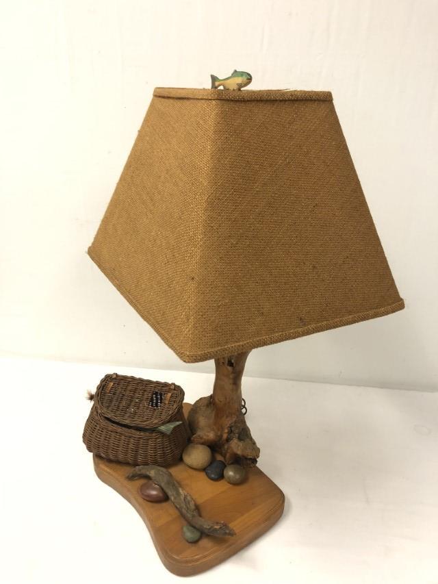 VINTAGE COUNTRY STYLE FISHING CREEL TABLE LAMP: Vintage country style fishing creel table lamp. Measures a total of 30" tall to fish form finial. Swivel design fixture. Condition: normal signs of age, tested and working, may need rewiring for conti