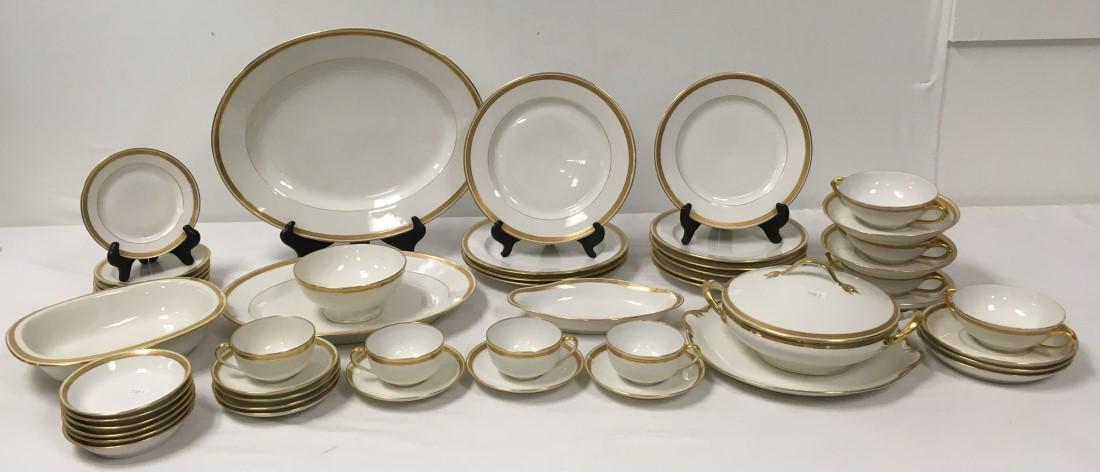 TRESSEMANN & VOGT LIMOGES PORCELAIN DINNERWARE: Tressemann & Vogt gold banded porcelain dinnerware. Includes (4) 9.5" plates, (6) 8.75" plates, (6) 6" bread plates, (7) 5.5" saucers, (6) 5" low bowls, (6) 6.7" bouillon saucers, (4) 4.75" diameter b