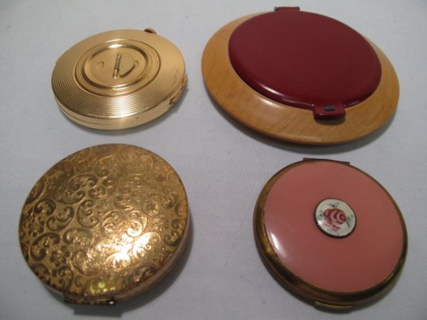 LOT OF FOUR VINTAGE ASSORTED LADIES COMPACTS: Lot of four vintage assorted ladies compacts. Includes Zell Fifth Avenue, Luzier, and Elizabeth Arden. All have mirrors intact. All include original puffs and sifters. The Elizabeth Arden compact feat