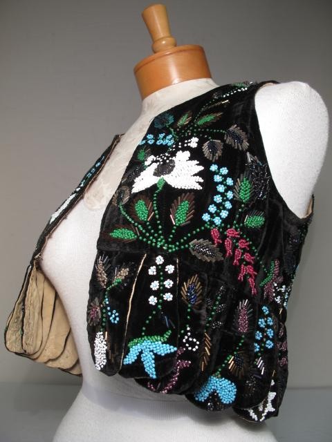 VINTAGE BLACK VELVET HEAVILY BEADED VEST: Vintage black velvet heavily beaded vest. Heavily beaded and floral deign with seed pearls and bugle beads. Good condition with a few frays at shoulders. Measures 16 inches to bottom, and 15 inches wi