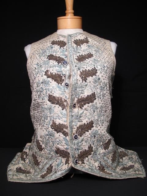 MID 19TH CENTURY MANS VEST: Mid 19th century mans vest. Vest made of a type of heavy linen. Front fabric seems to be a heavy satin? Front is embellished with sequins and embroidery. Rhinestone buttons adorn the closure and pocke