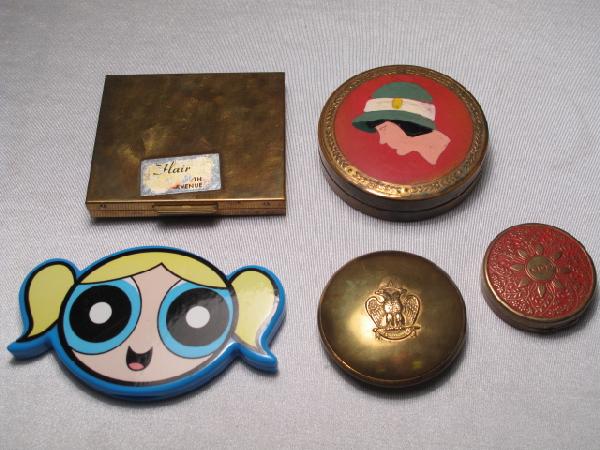 FIVE VINTAGE LADIES POWDER COMPACTS: Five vintages ladies powder compacts including a souvenir compact from New Castle, Pennsylvania. Largest compact measures 2 3/4" x 2 1/4". Smallest is 1 1/2" in diameter. Total weight: 0.6 lbs. Condit