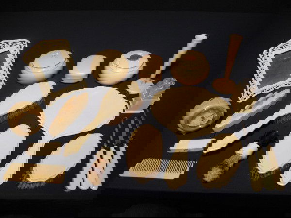 ART DECO CELLULOID (FRENCH IVORY) VANITY ITEMS: An assortment of vintage Art Deco vanity items including powder jars, frame, hair receiver, brushes, comb, manicure items, travel clock, vase, hand mirror and button hook. All are faux ivory (or Frenc