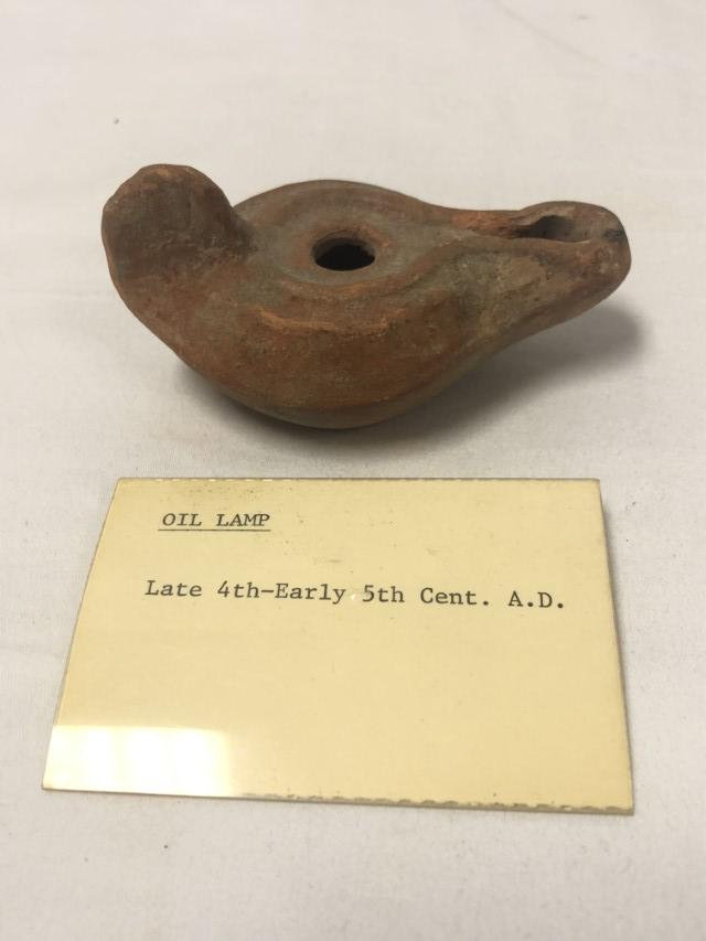 ROMAN POTTERY OIL LAMP 4TH-5TH CENTURY C.E.: Roman pottery oil lamp, Late 4th-early 5th century C.E. Measures 3.55" long x 1.85" tall. Includes small information card. Condition: repaired damages and minor losses, see images. Weight: .1 lbs.