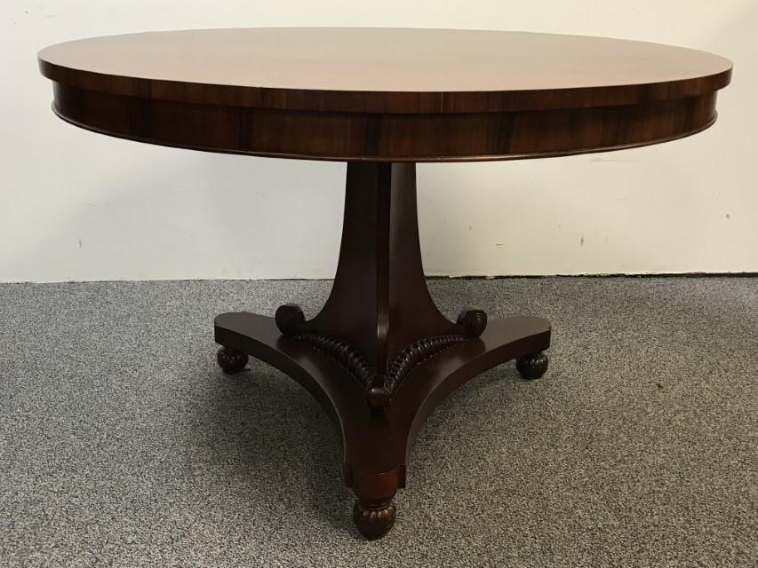 BUNNY WILLIAMS (US B.1944) ROSEWOOD CENTER TABLE: BUNNY WILLIAMS (US B.1944) ROSEWOOD CENTER TABLE. Sold by Beline Home (label on underside). Regency style circular pedestal base table with scroll and gadroon design at bottom and raised on ball feet.