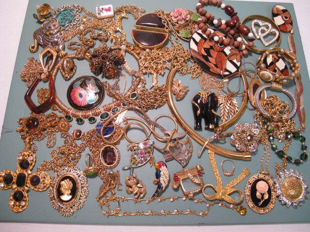 ASSORTED COSTUME JEWELRY PARKLANE TRIFARI ETC: Tray lot of assorted costume jewelry. Brands such as Parklane, Trifari, Romak and more. Gold toned, silver toned, enamel, faux gems, faux pearls, wood, and more! Includes necklaces, rings, bracelets,