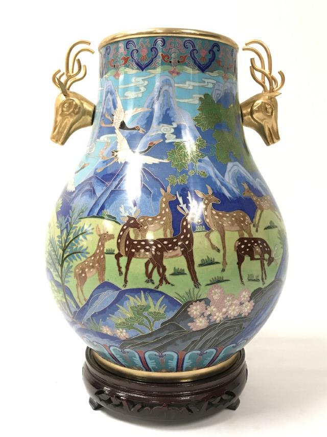 CHINESE: CLOISONNE VASE AND ROSEWOOD STAND: CHINESE cloisonne vase. Deer and crane motif and stag head handles on a wood stand, vase H 15", Dia 11"; Weight estimate approx. 15 lbs. total. Condition: good, one deer handle ear is bent.